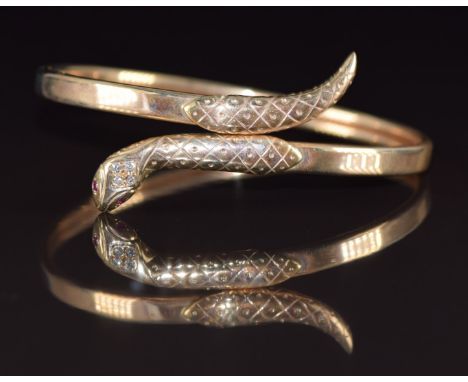 A 9ct gold bangle in the form of a snake set with diamonds and ruby eyes, 11.1g, 6 x 5cm&nbsp;
