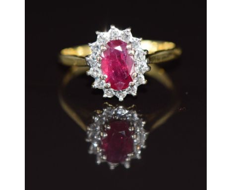 An 18ct gold ring set with an oval cut ruby of approximately 0.7ct&nbsp;surrounded by diamonds, 2.4g, size J