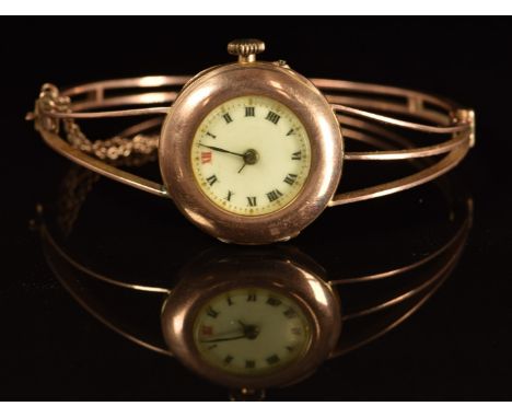 A 9ct rose gold ladies bangle wristwatch with blue hands, Roman numerals, gilt decorated white dial and signed movement, case