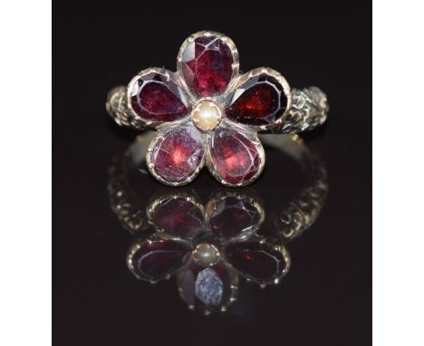 Victorian ring set with a seed pearl and foiled garnets in a floral cluster, with embossed floral shoulders, 3.4g, size K