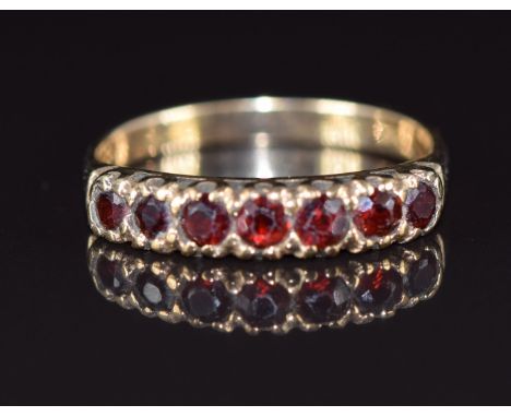 A 9ct gold ring set with seven round cut garnets, 2.3g, size Q