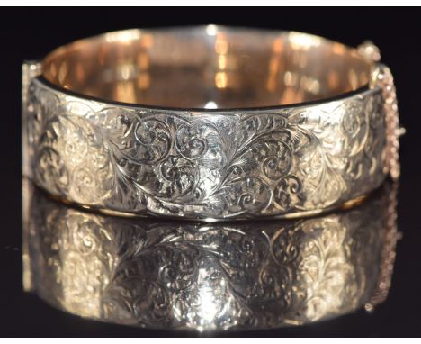 A 9ct gold bangle with engraved scrolling decoration, 28g, 6 x 5.5cm