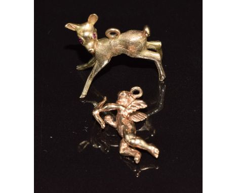 A 9ct gold charm/ pendant in the form of a fawn with synthetic ruby eyes and a 9ct gold charm in the form of Cupid, 7.6g