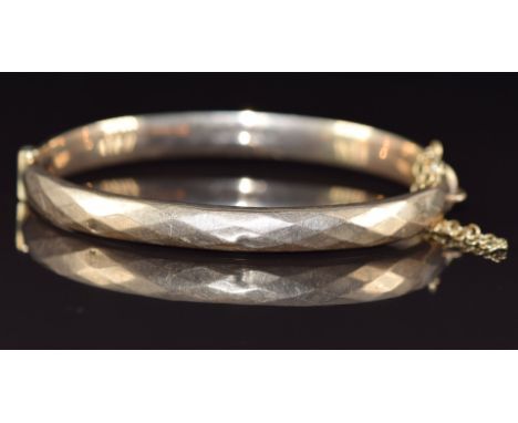 A 9ct gold bangle with faceted decoration, Birmingham 1971, 9.8g, 6 x 5.2cm&nbsp;