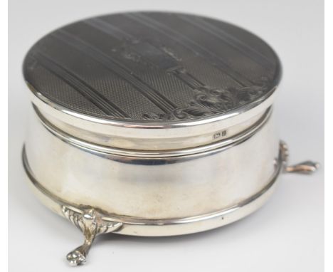 Elizabeth II hallmarked silver circular dressing table jewellery casket with engine turned decoration, raised on three feet, 