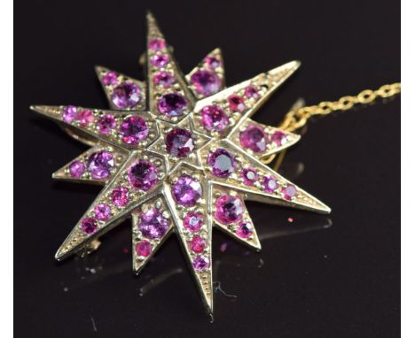 A 9ct gold pendant / brooch in the form of a star set with rubies, 8.4g, 3.5cm (one ruby missing)