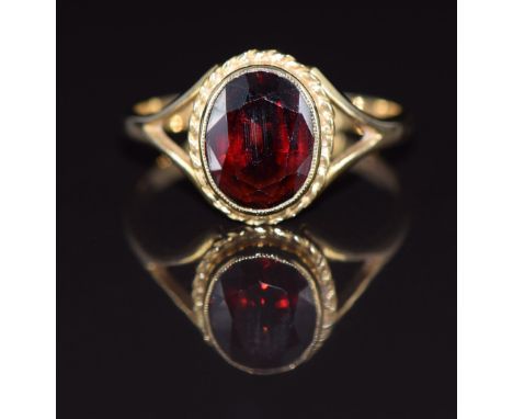 A 9ct gold ring set with an oval cut garnet, 2.3g, size L