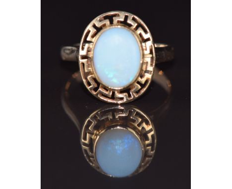 A 9k gold ring set with an opal within a Greek key border, 2.7g, size L