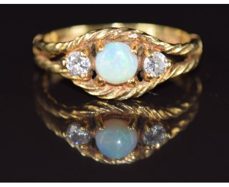 An 18ct gold ring set with an opal and two round cut diamonds, each approximately 0.08ct, in a rope twist border, 3.2g, size 