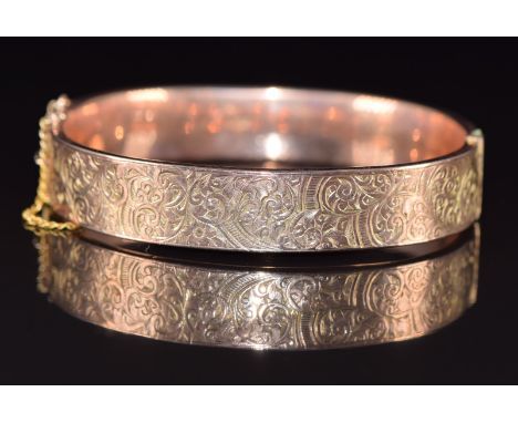 A 9ct rose gold bangle with engraved scrolling decoration, Chester 1919, 16g, 6 x 5cm