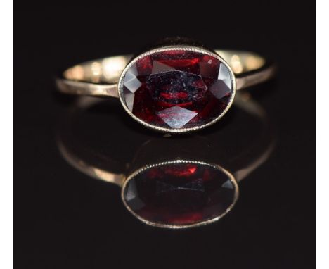 A 9ct gold ring set with an oval cut garnet, 1.7g, size K