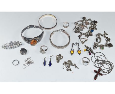 A collection of silver jewellery including pressed amber bracelet, bangle, two bracelets, two charm bracelets, five rings one