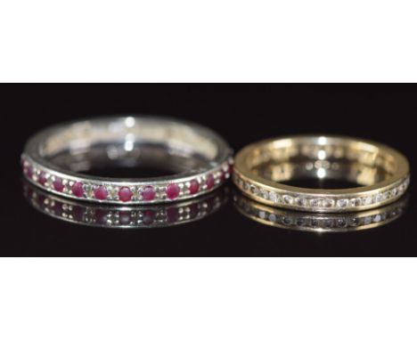 A 9ct white gold eternity ring set with rubies (2.3g, size T) and a 9ct gold eternity ring set with diamonds, 1.6g, size L