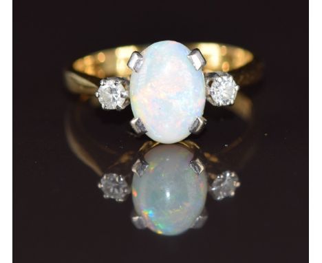 An 18ct gold ring set with an oval cut opal cabochon and diamonds, 3.1g, size J