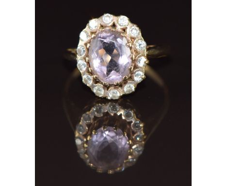 A 9ct gold ring set with an oval cut amethyst surrounded by paste, 3.8g, size R