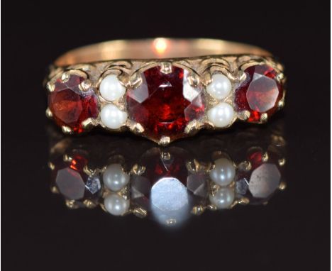 A 9ct gold ring set with round cut garnets and pearls, 3.1g, size T
