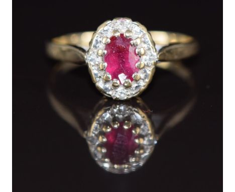 A 9ct gold ring set with an oval cut ruby of approximately 0.4ct&nbsp;surrounded by diamonds, 2.1g, size M