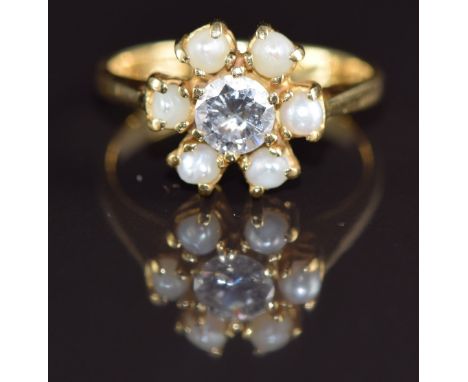 An 18ct gold ring set with a round cut diamond of approximately 0.5ct surrounded by pearls, 4.7g, size M/ N