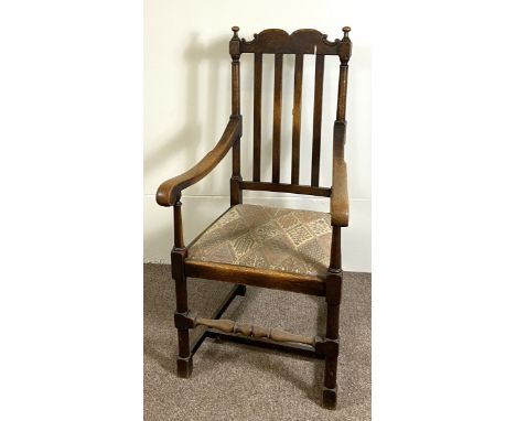 A vintage Jacobean style beech wood framed armchair