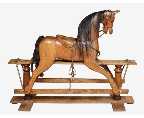 An oak rocking horse, with chestnut mane and tail, on a trestle rocker frame supported by dual baluster columns, dual plinth 