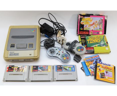 A Super Nintendo console, with two controllers and five games, to include Street Fighter 2 and Frantic Flea. (8)