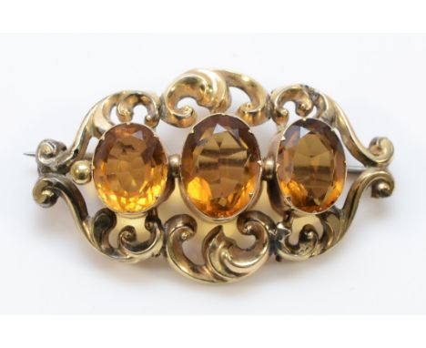 A Victorian unmarked gold and citrine brooch, scroll frame, 43mm, 8.4gm