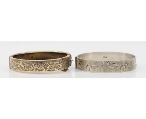 A gold on silver hinged bangle, 57 x 52mm and a silver hinged bangle, Birmingham 1973, 49gm (2)
