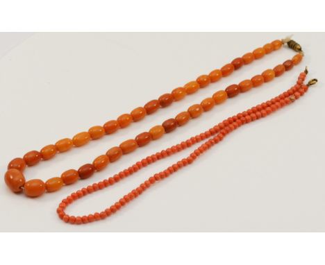 A Bakelite butterscotch amber bead necklace, 15 - 7mm beads, 42cm, 16gm and a coral bead necklace (2)