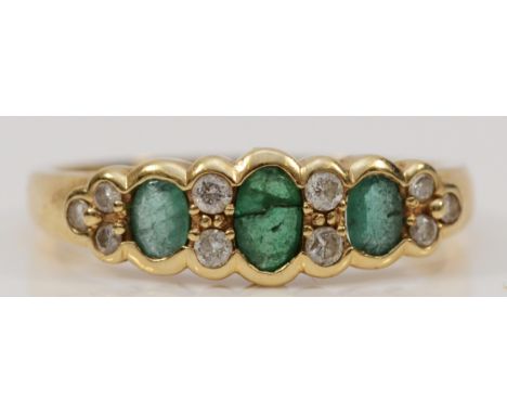 A 9ct gold emerald and brilliant cut diamond dress ring, three emeralds the central of which is cracked, R, 2.6g