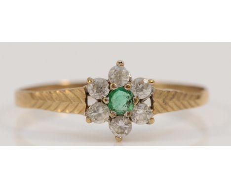 A 9ct gold emerald and cubic zirconia floral cluster ring, with patterned shoulders, U, 1g