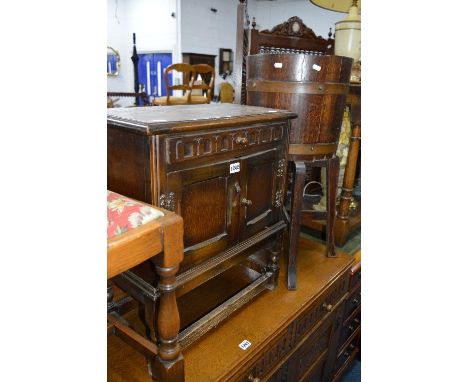 A SMALL OAK TWO DOOR CABINET and an oak planter with copper banding on a separate stand (2)