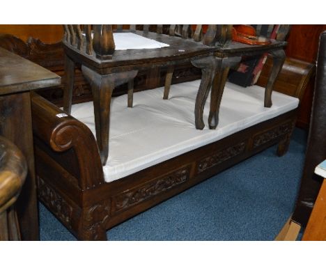 A LARGE CARVED HARDWOOD THREE SEATER BENCH, with scrolled ends, three drawers and removable cushions, approximate size width 