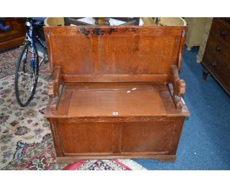 AN OAK MONKS BENCH, with carved lion supports