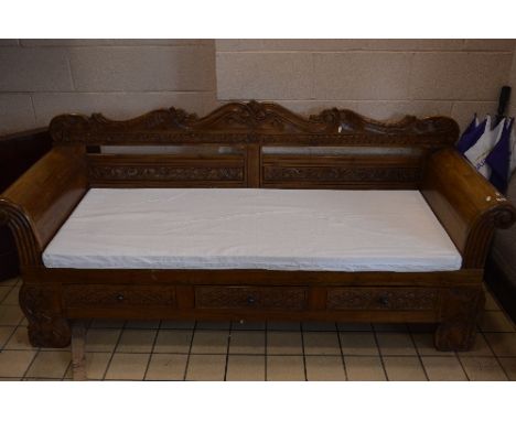 A LARGE CARVED HARDWOOD THREE SEATER BENCH, with scroll ended arms, three drawers and removable cushions, approximate size wi