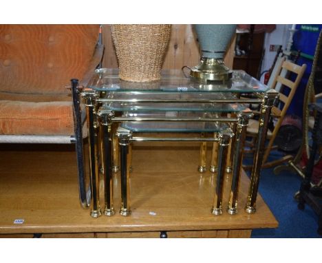 A BRASSED FRAMED NEST OF THREE TABLES WITH GLASS INSERTS, a matching coffee table, modern table lamp, modern ceiling light an