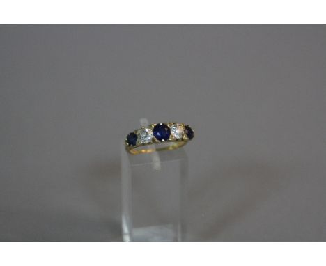 A SAPPHIRE AND DIAMOND RING, with three graduated round cut sapphires and two old round cut diamonds, each approximately .33c