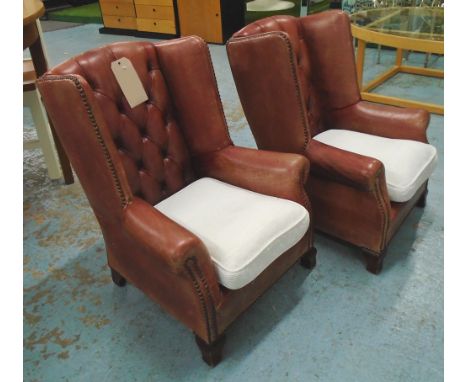 CHILDREN'S WINGBACK ARMCHAIRS, a pair, in buttoned worn leather with white cord cushion seats, 55cm x 46cm x 73cm H. (2)