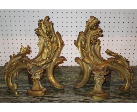 CHENETS, a pair, late 19th century French gilt bronze with leaf decoration, 20cm W x 22cm H. (2)