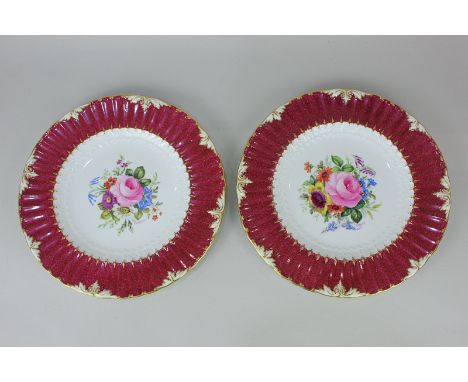 A pair of Royal Crown Derby porcelain cabinet plates with floral decoration, signed F Garnett, on white ground surrounded by 