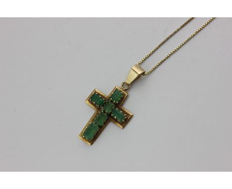 An emerald cross pendant claw set with six step cut stone in unmarked yellow gold on an 18 carat gold box link chain with bol