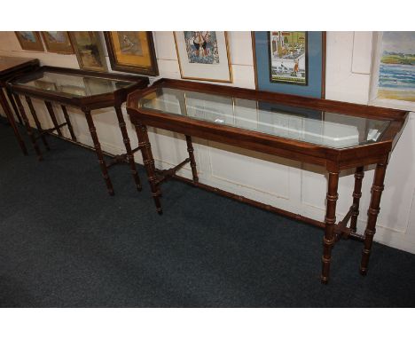 A pair of mahogany glass-topped console tables, rectangular shape with cut corners and shaped gallery tops, bevelled glass in