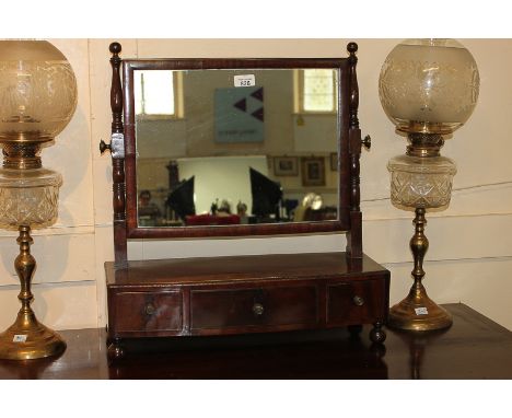 A rectangular framed dressing table mirror on bow front box base with three drawers, on ball feet