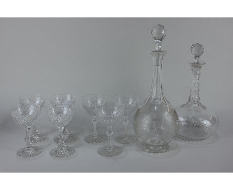 Two glass decanters, shaft and globe shaped, one engraved with fruiting vines, 33.5cm, the other with faceted stem, 28.5cm, t
