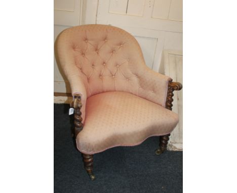 A Victorian button upholstered armchair with carved scroll arms, spiral supports, turned legs and castors