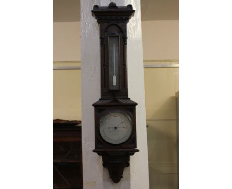 A carved oak thermometer and barometer marked Negretti &amp; Zambra London 7919, 71cm high