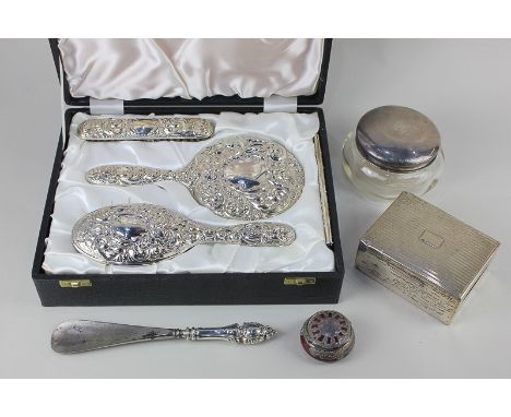 A modern silver backed four-piece dressing table set embossed with masks, scrolling foliage and birds, comprising hairbrush, 