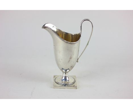 An Edward VII Adam style silver cream jug, helmet shaped on square pedestal foot, maker Haseler Brothers, London 1902, 3oz, 1