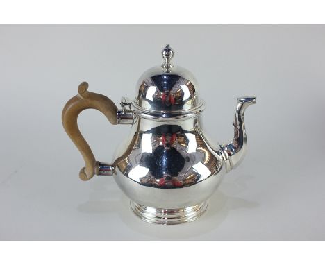 An Elizabeth II silver Queen Anne style teapot, makers Wakely &amp; Wheeler, London 1967, with wooden handle, 20oz