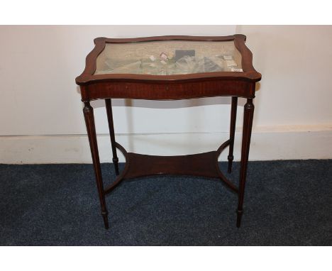 A 19th century inlaid mahogany vitrine, the scalloped form on tapered legs with uniting stretcher shelf, 61cm wide