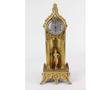 An unusual gilt metal mantle clock,with two inch silvered dial and Roman numerals in Gothic arched case in the form of a sent